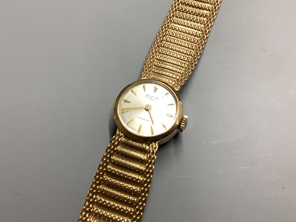 A lady's modern 9ct gold Avia manual wind wrist watch, on integral 9ct gold bracelet, overall 17.5cm